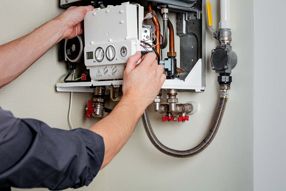 Technicien réalisant l'entretien d'une chaudière à gaz