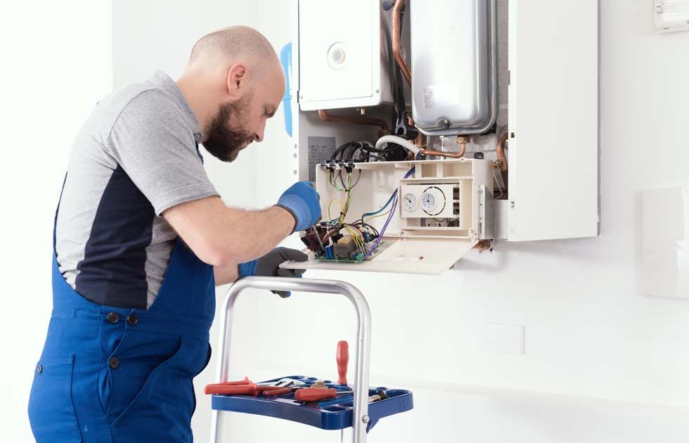 Qualified engineer servicing a boiler Professional qualified engineer servicing a natural gas boiler at home